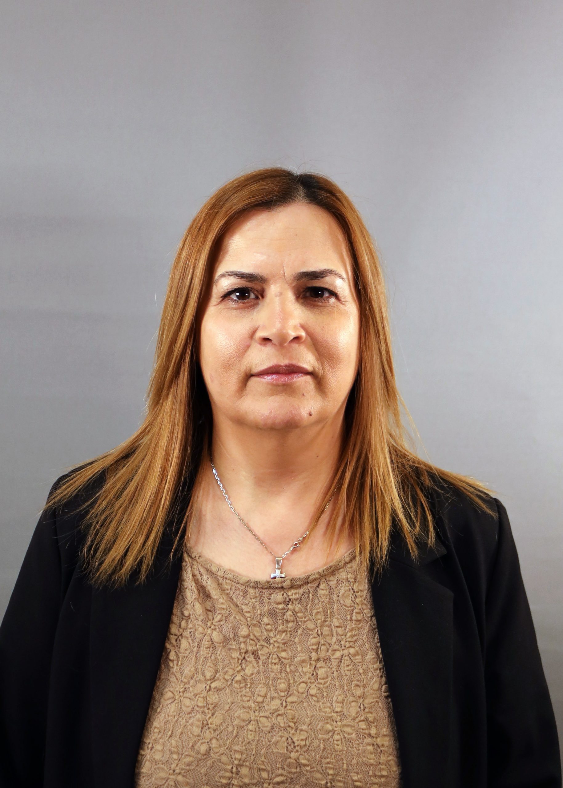 En kvinna med rakt ljusbrunt hår, klädd i svart kavaj och beige topp, vänd mot kameran.