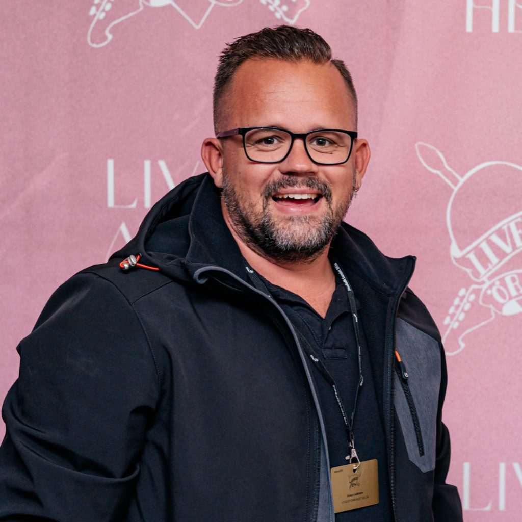 Man i glasögon och rosa bakgrund