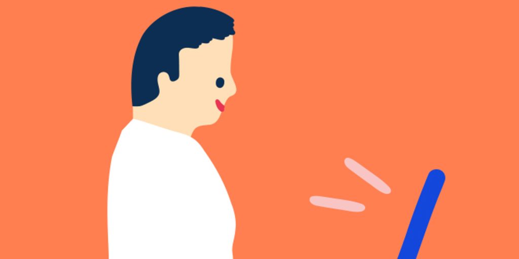 En man använder en bärbar dator på en orange bakgrund.