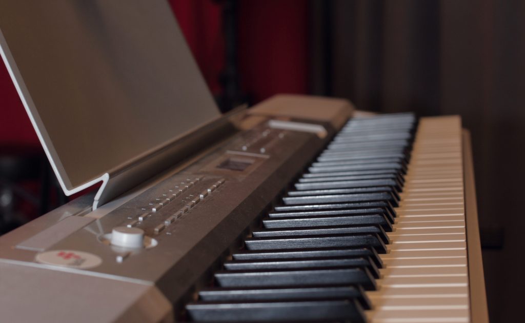 Närbild av ett digitalt pianoklaviatur med svarta och vita tangenter och kontrollknappar synliga.