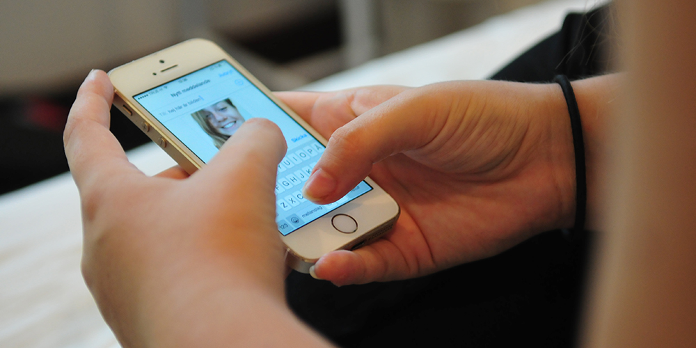 Person som håller i mobiltelefon