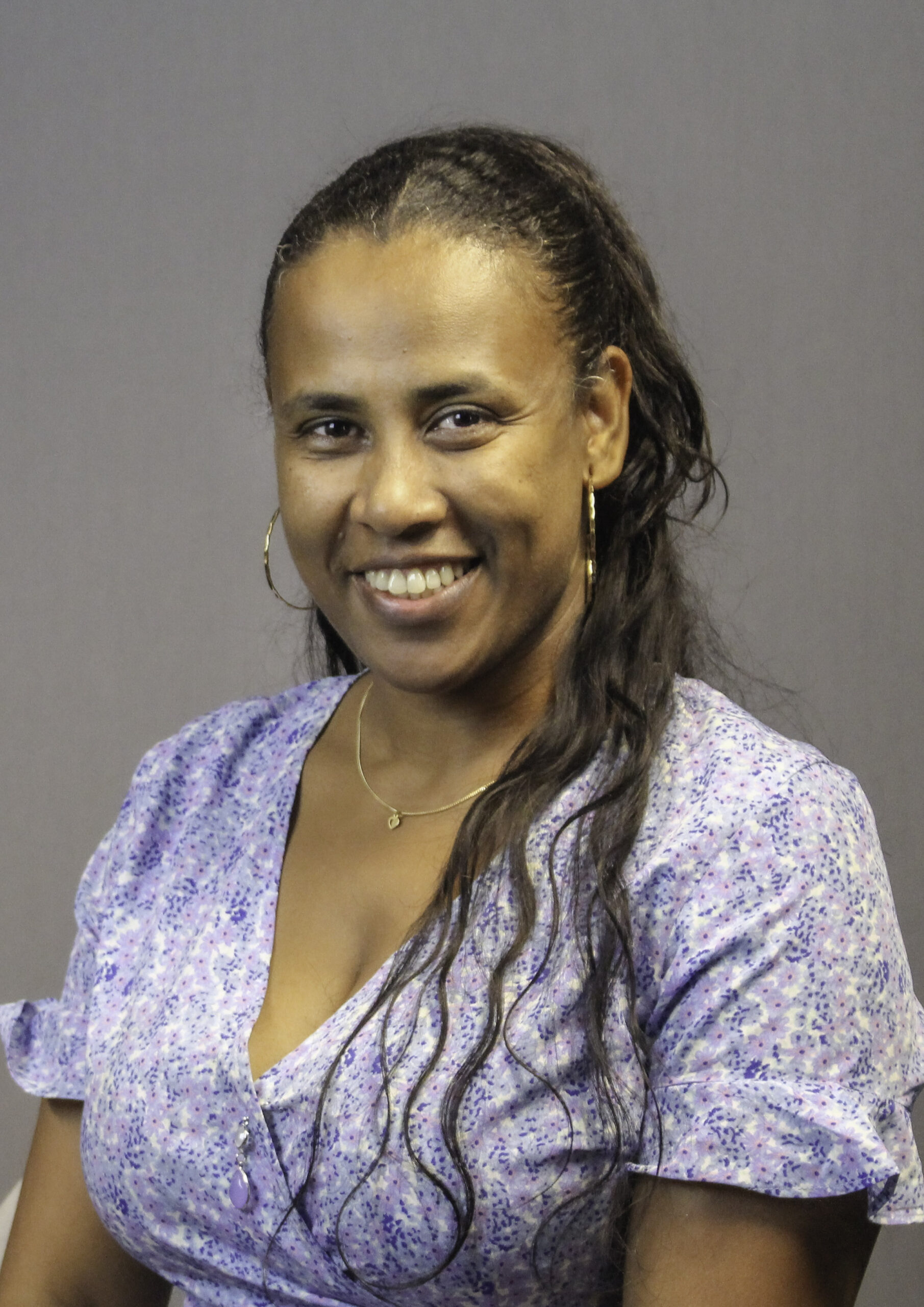 Ellen i en lila klänning ler mot kameran.