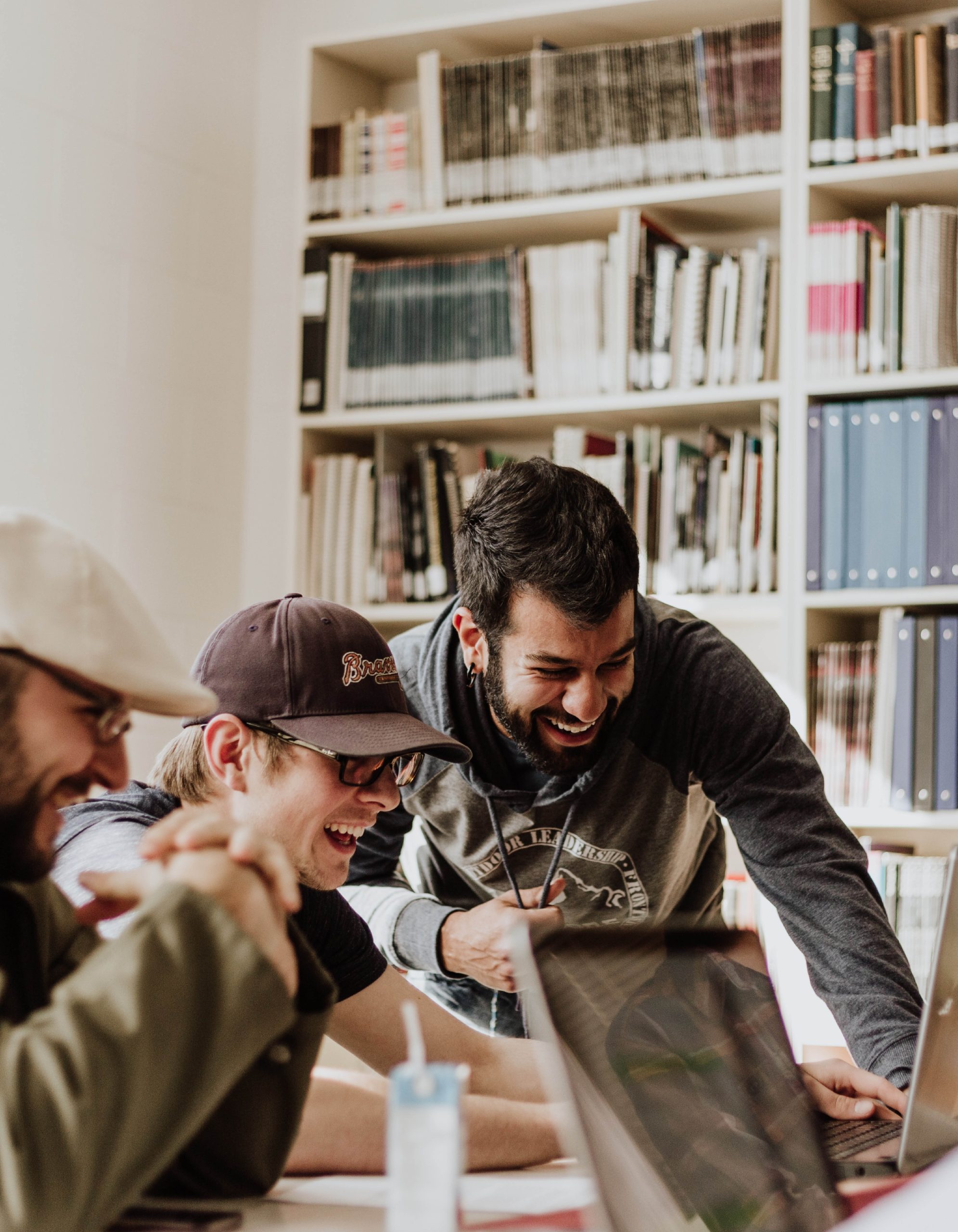 Tre män som skrattar vid en datorskärm