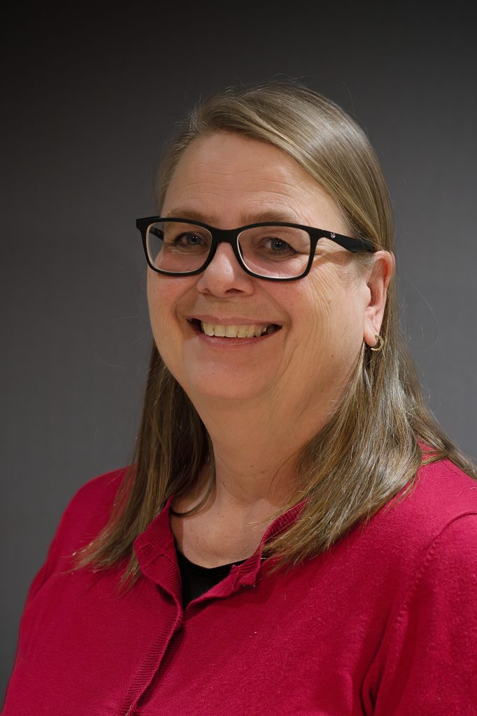 En kvinna som bär glasögon och en röd skjorta.