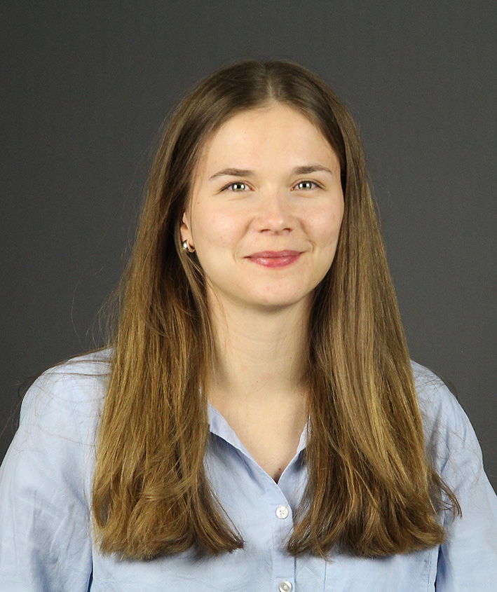 Porträttbild på Johanna med grå bakgrund