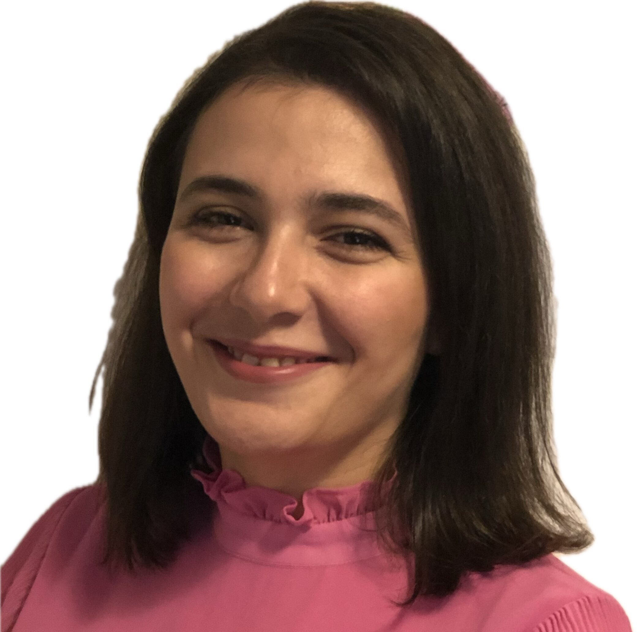 En person med axellångt mörkt hår som bär en rosa topp ler mot kameran mot en vit bakgrund.