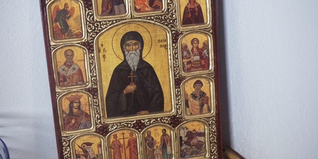 Ortodox kristen ikon med central helgonfigur och mindre omgivande religiösa scener på guldfärgad bakgrund.