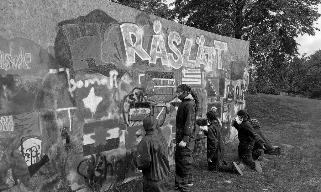 Ungdomar som målar graffiti på en vägg