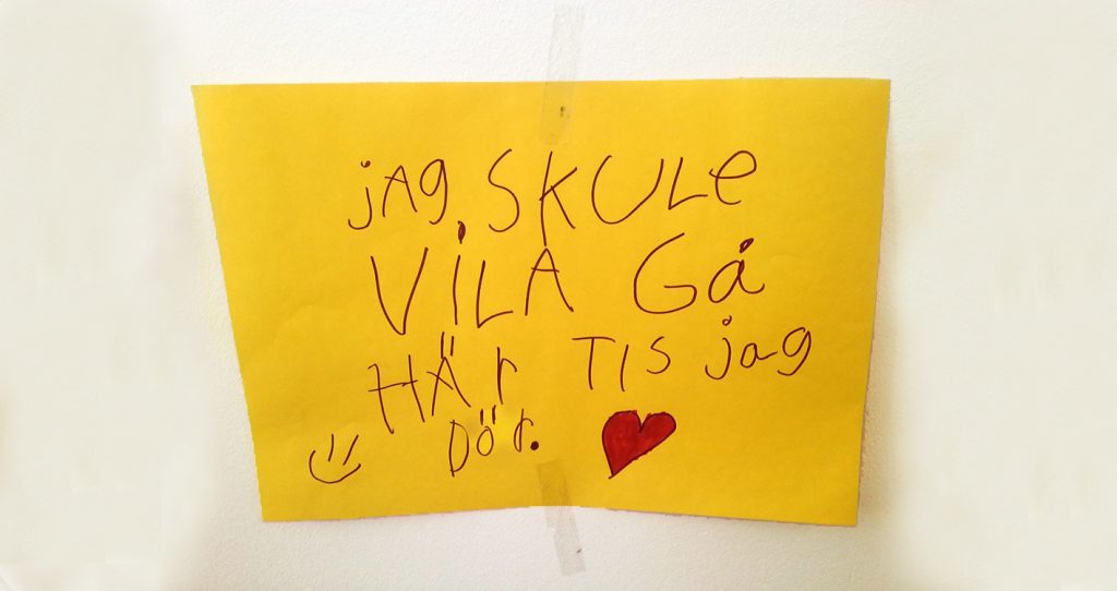 En handskriven lapp på svenska på gult papper med hjärtan och smiley-teckningar.