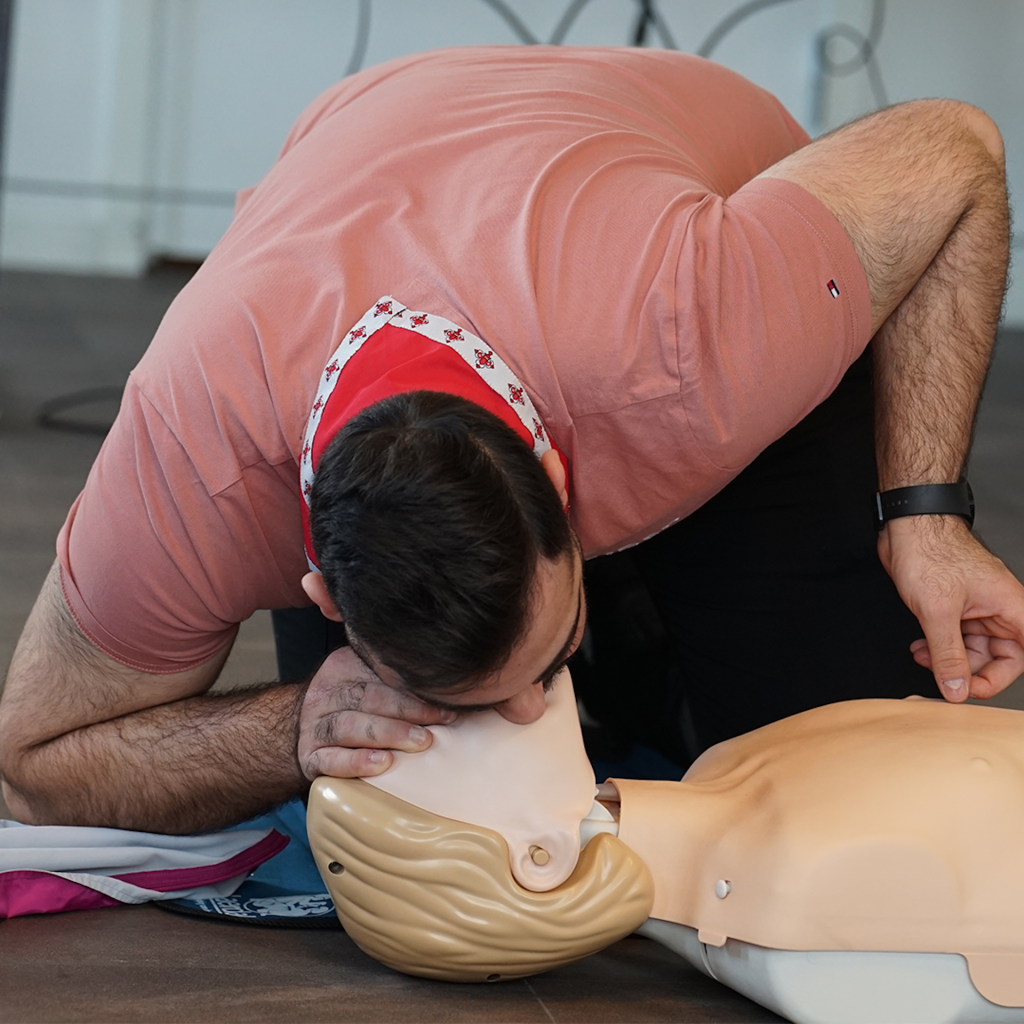 En person övar hjärt-lungräddning med mun-mot-mun-metoden på en träningsdocka.