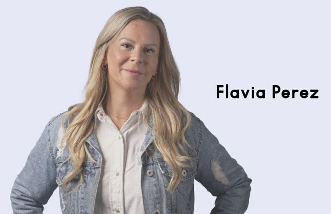 Kvinna med långt blont hår i jeansjacka ler, texten lyder "Flavia Perez" på höger sida.