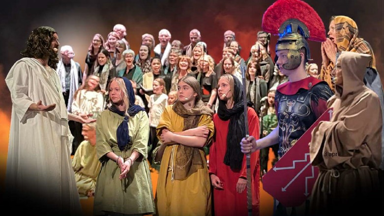 En scenföreställning med skådespelare i antika kläder och rustningar och en stor kör i bakgrunden.