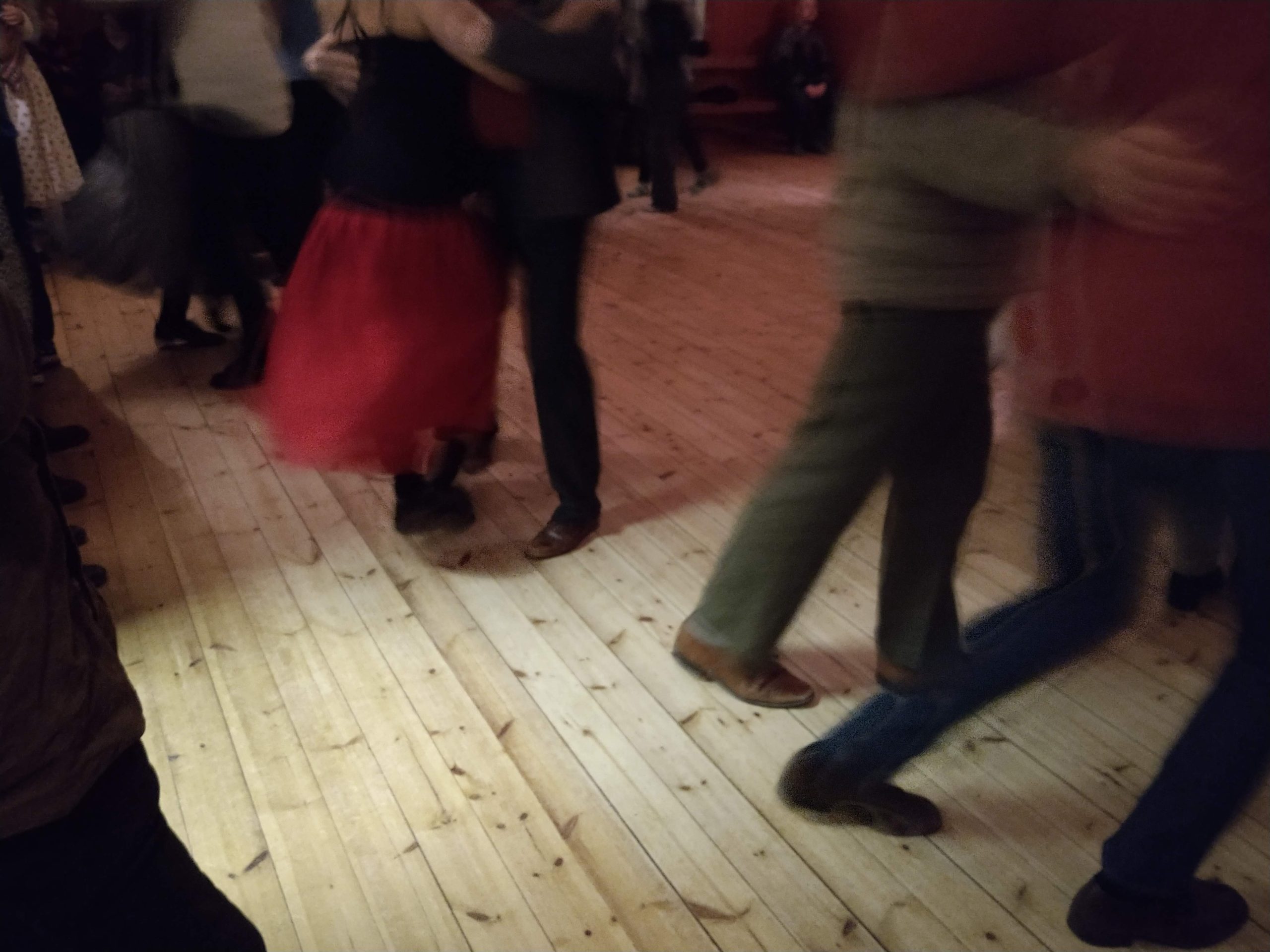 En grupp människor som dansar på ett trägolv.