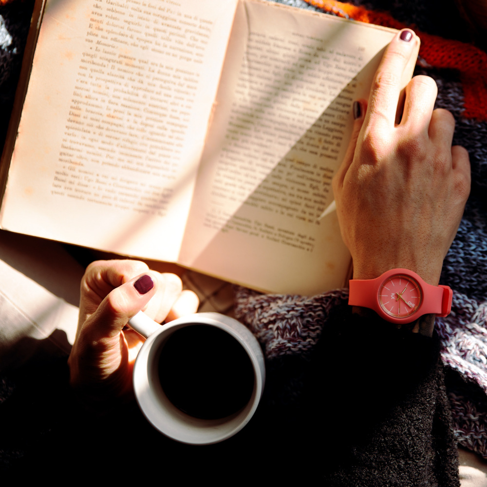 Läser bok och dricker kaffe