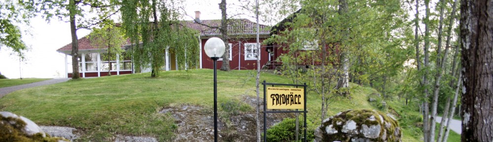 Ett rött hus med tegeltak ligger bland gröna träd och gräs, med en gul "Frängsäter"-skylt framför.