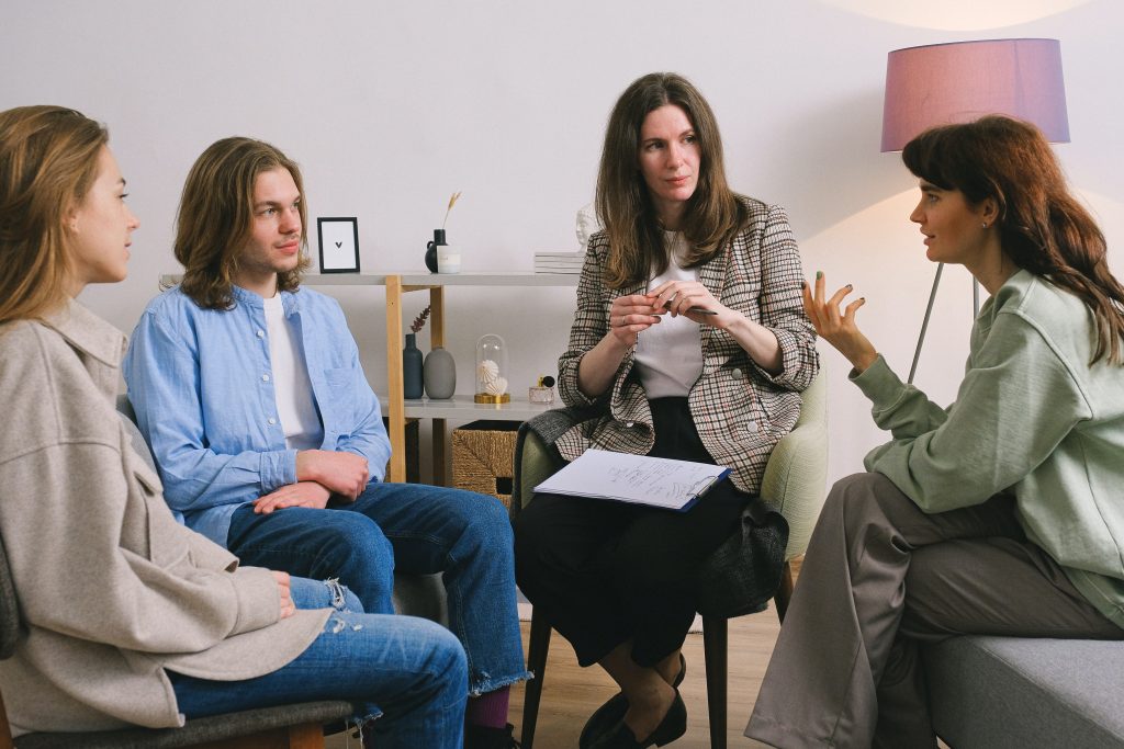 En grupp kvinnor som sitter runt varandra och pratar.