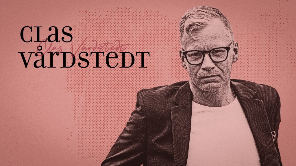 En man med glasögon och kavaj mot en röd bakgrund, med texten ”Clas Värdstedt” bredvid honom.