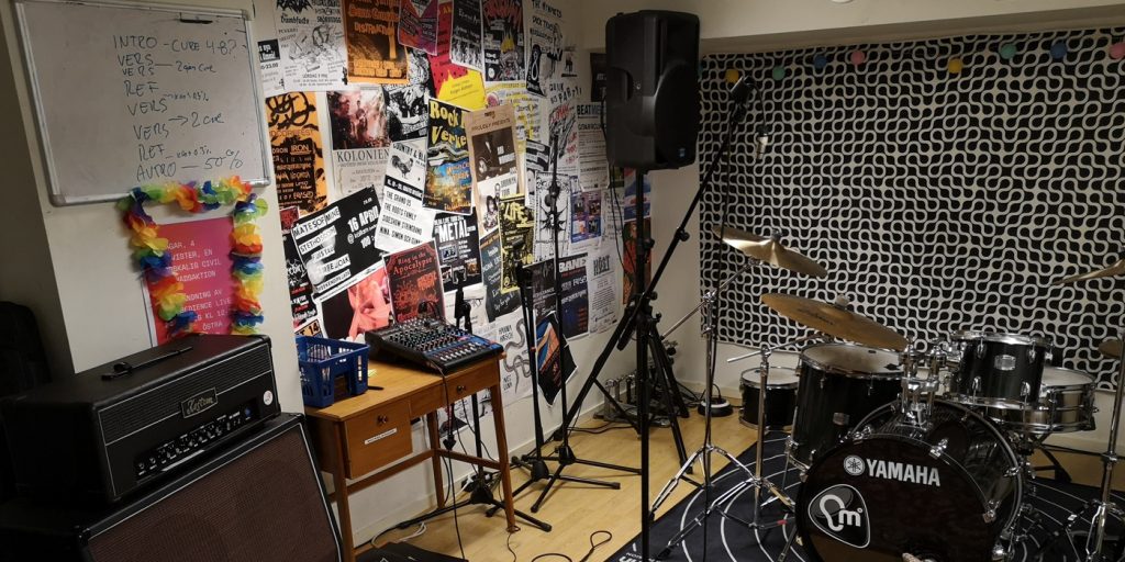 Del av en replokal med trumset och mixerbord och micar.