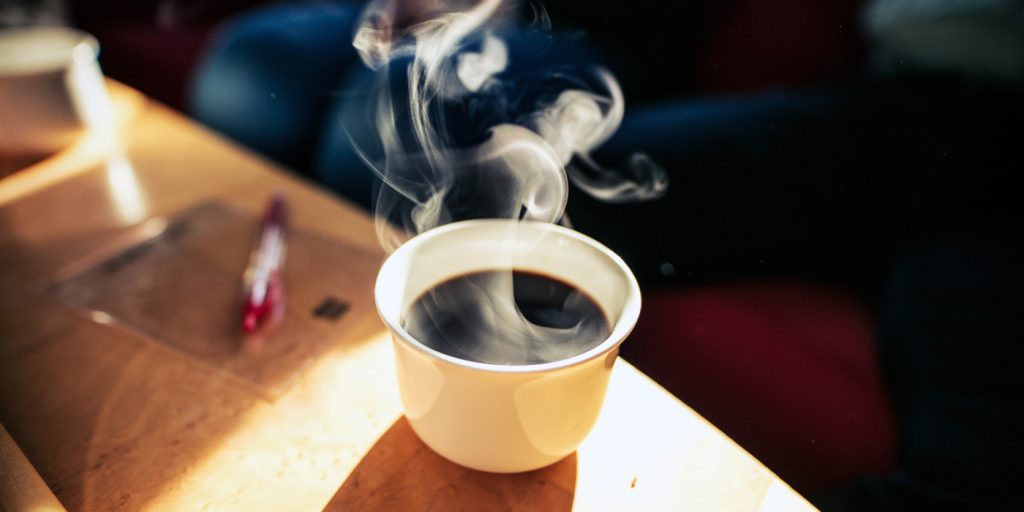 En kaffekopp som sitter på toppen av ett träbord.