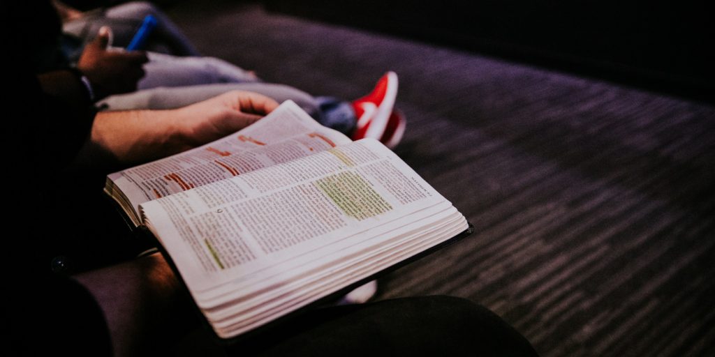En person som sitter i en soffa och läser en bok.