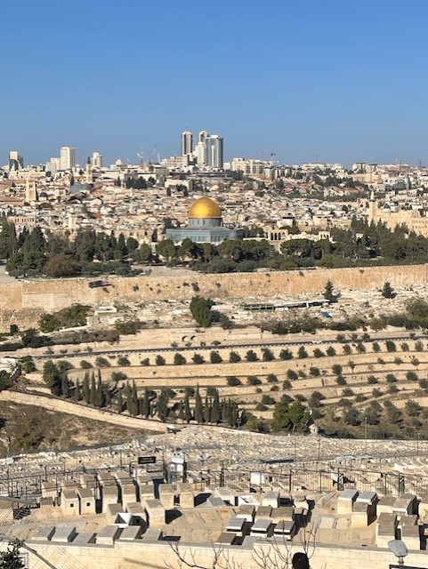 Utsikt över Jerusalem med den guldfärgade Klippdomen, stadens byggnader och det terrasserade landskapet under en klar himmel.