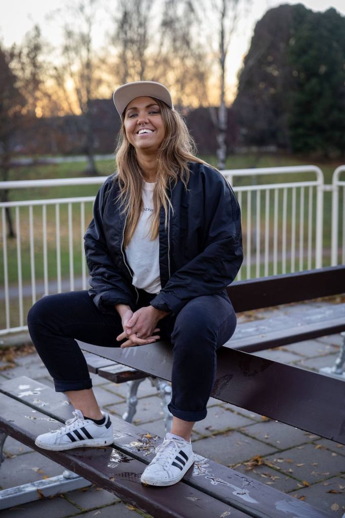 En kvinna som sitter på ett bord utomhus