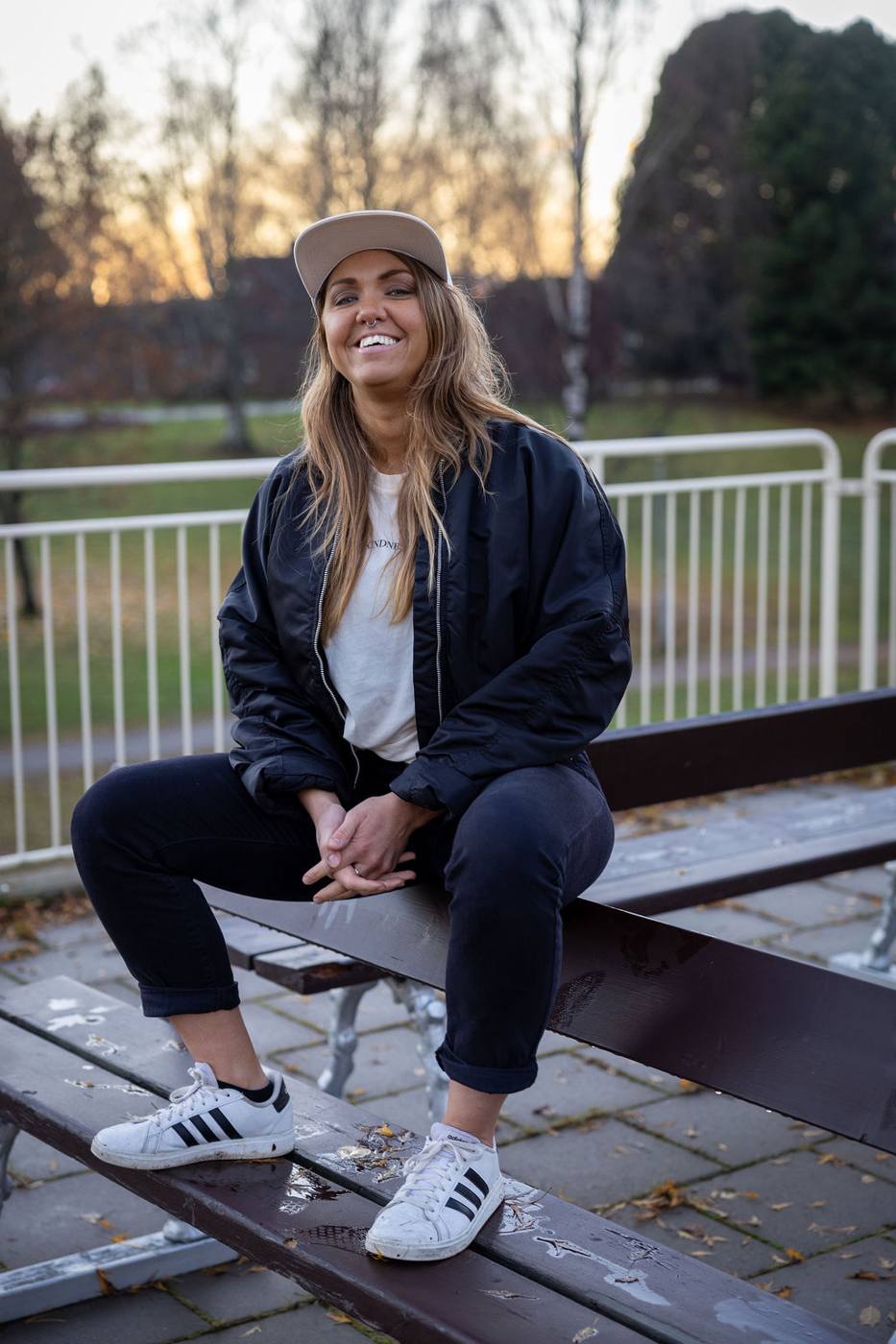 En kvinna som sitter på ett bord utomhus